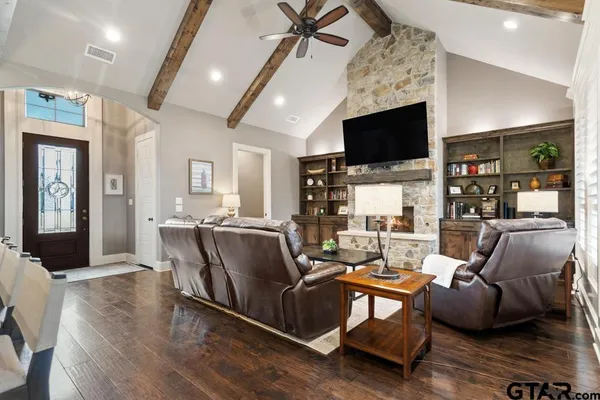 a living room with furniture a flat screen tv and a fireplace