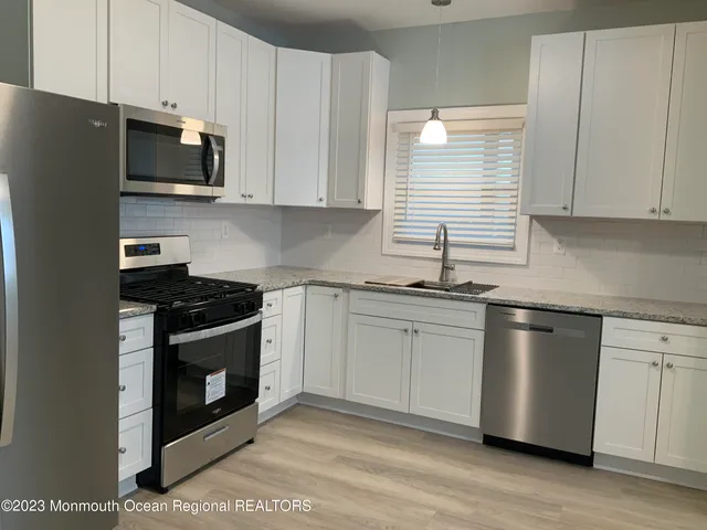 a kitchen with stainless steel appliances granite countertop a stove a microwave and a refrigerator