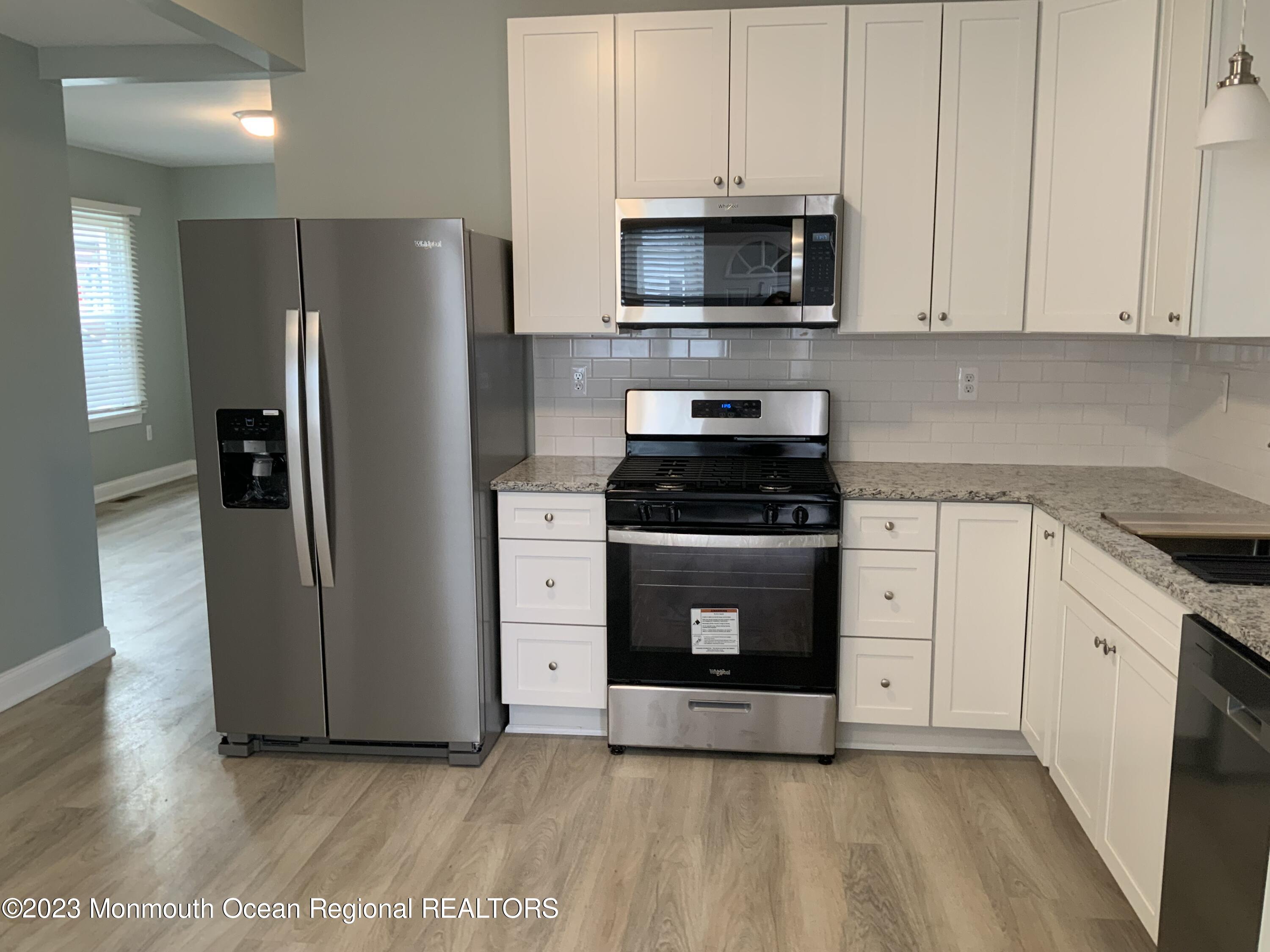 104 Bridge Avenue, Unit APARTMENT 1 Red Bank, NJ 07701 - Photo 12 of 25 a kitchen with cabinets stainless steel appliances and wooden floor