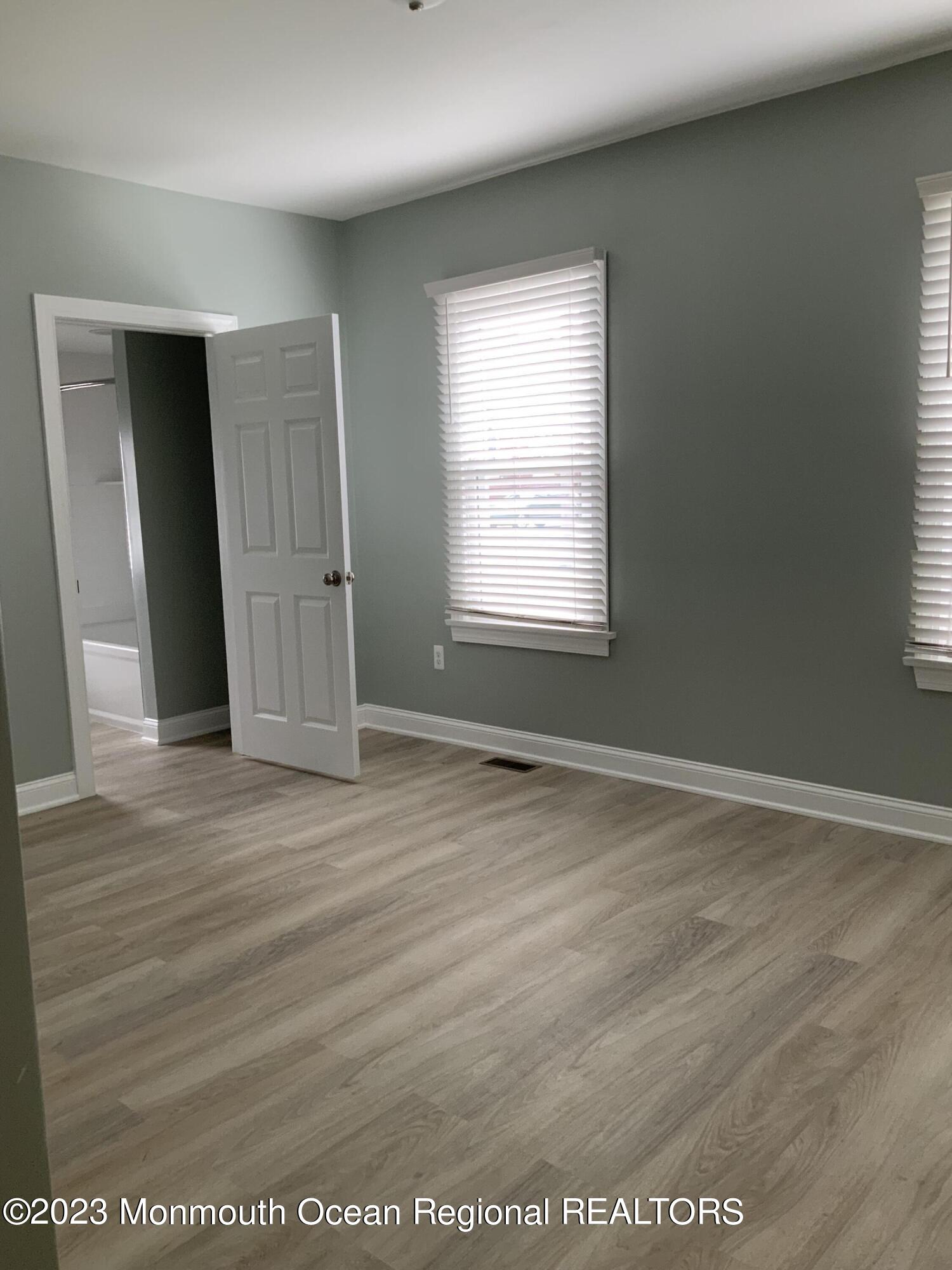 104 Bridge Avenue, Unit APARTMENT 1 Red Bank, NJ 07701 - Photo 17 of 25 an empty room with wooden floor and windows