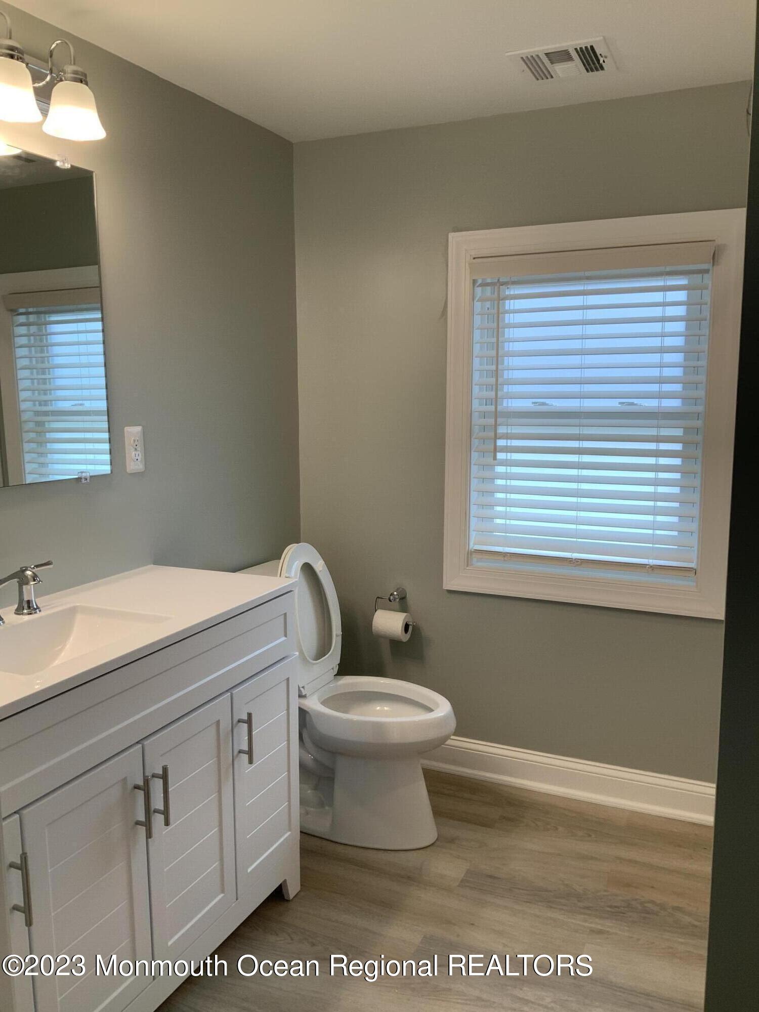 104 Bridge Avenue, Unit APARTMENT 1 Red Bank, NJ 07701 - Photo 22 of 25 a bathroom with a toilet sink and mirror