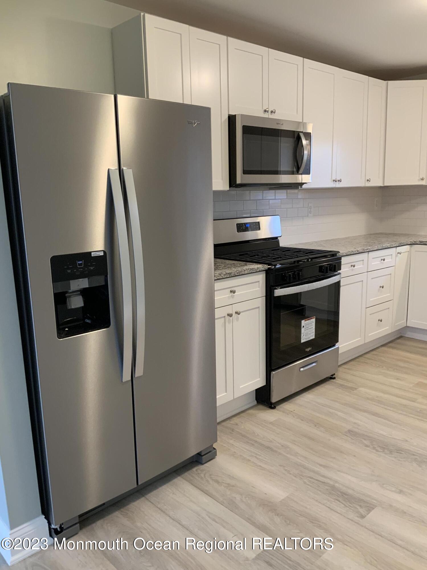 104 Bridge Avenue, Unit APARTMENT 1 Red Bank, NJ 07701 - Photo 5 of 25 a kitchen with stainless steel appliances a refrigerator stove and microwave