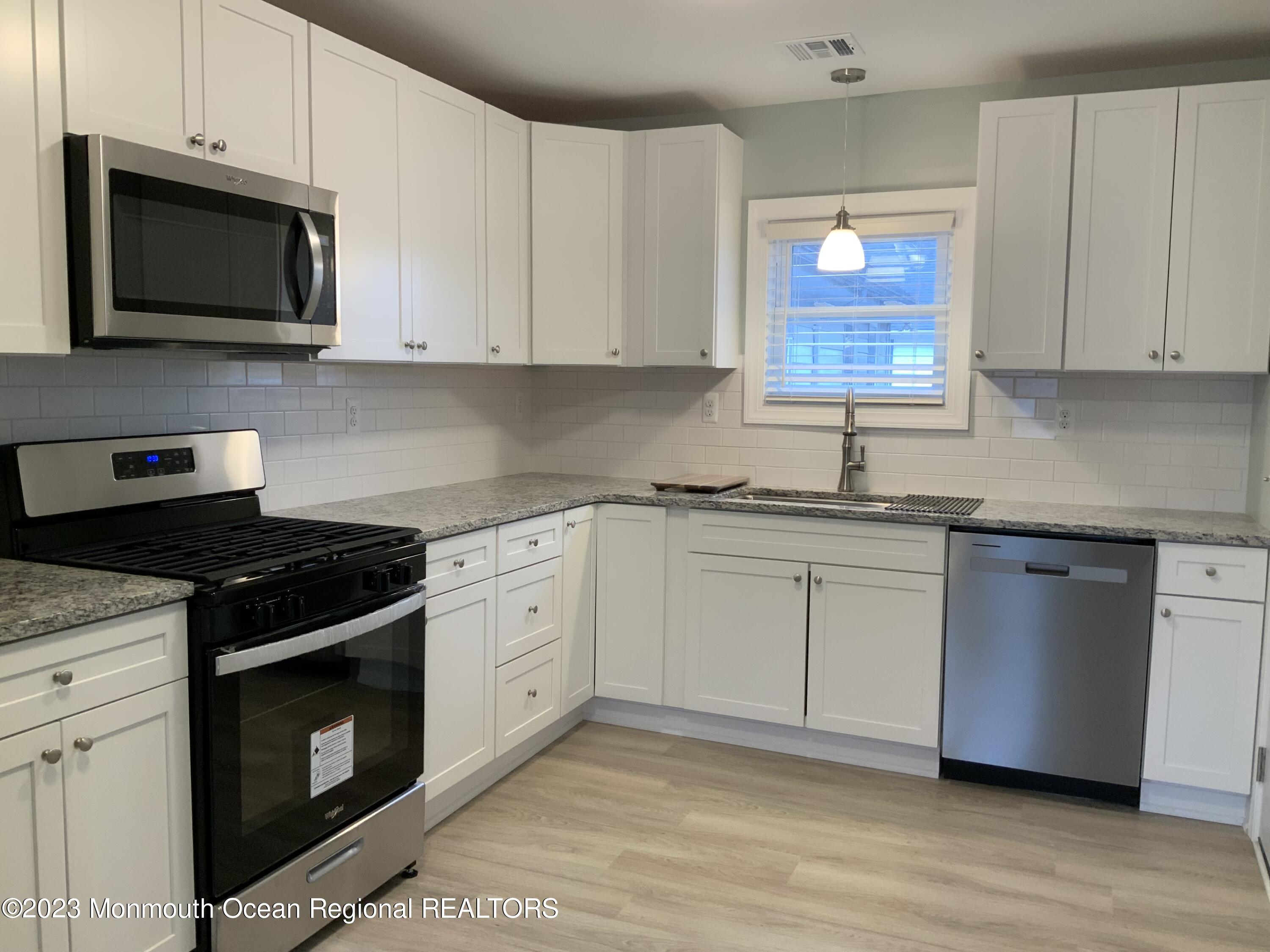 104 Bridge Avenue, Unit APARTMENT 1 Red Bank, NJ 07701 - Photo 6 of 25 a kitchen with stainless steel appliances granite countertop a stove a sink and a microwave
