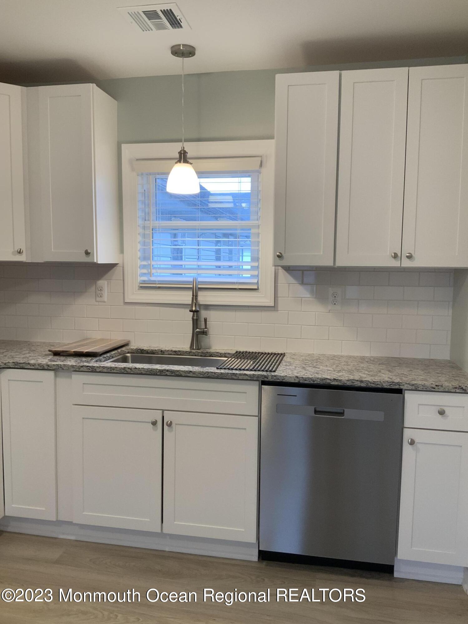 104 Bridge Avenue, Unit APARTMENT 1 Red Bank, NJ 07701 - Photo 7 of 25 a kitchen with stainless steel appliances granite countertop a sink a stove and white cabinets