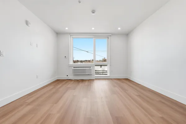 a view of a room with wooden floor and window