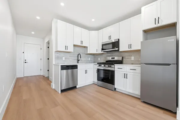 a kitchen with stainless steel appliances white cabinets and a refrigerator