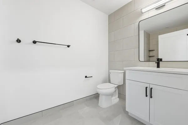 a bathroom with a sink mirror vanity and toilet