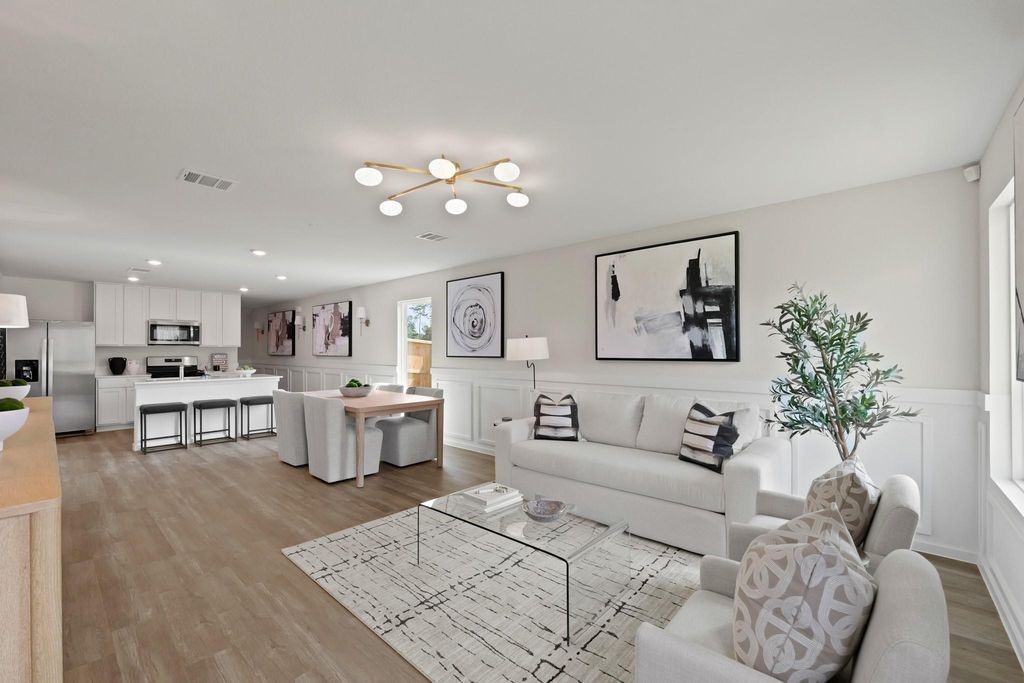 a living room with furniture and view of kitchen