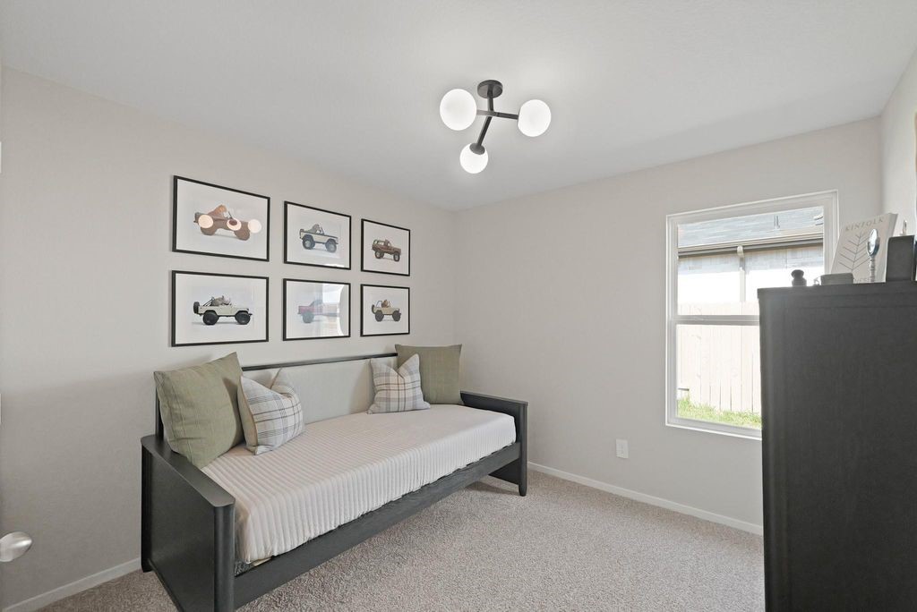 24114 Chirp Street Splendora, TX 77372 - Photo 14 of 22 a bedroom with a bed and a chandelier