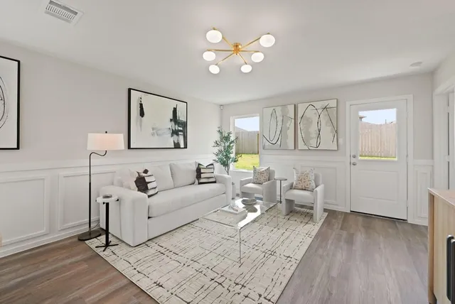 a living room with furniture a wooden floor and a large window