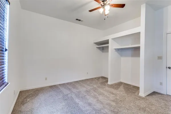 a view of an empty room with a ceiling fan