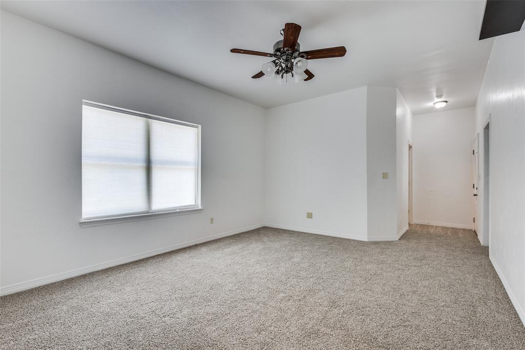 618 East Woodard Street Denison, TX 75021 - Photo 4 of 22 an empty room with a window and a ceiling fan