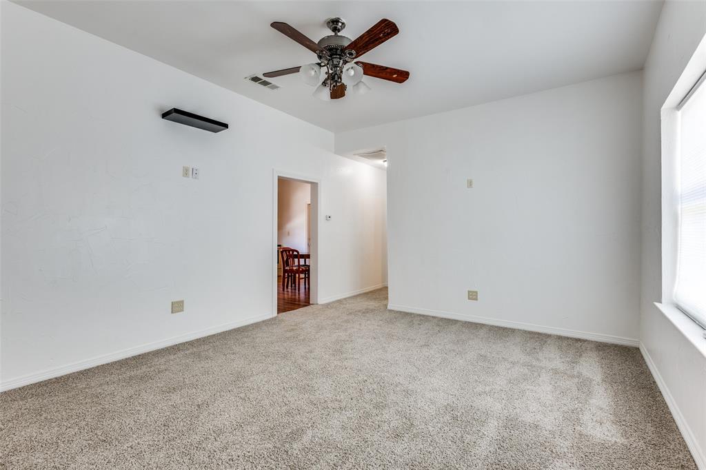 618 East Woodard Street Denison, TX 75021 - Photo 6 of 22 an empty room with a window and a fan