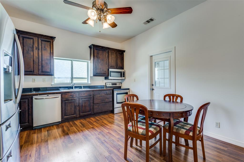 618 East Woodard Street Denison, TX 75021 - Photo 8 of 22 a kitchen with stainless steel appliances granite countertop a kitchen island hardwood floor sink stove dining table and chairs
