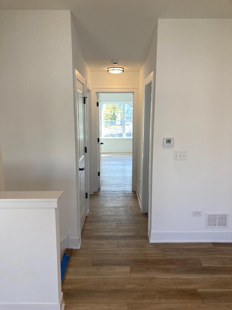 935 Saddle Ridge Drive Joliet, IL 60432 - Photo 13 of 21 a view of a hallway with wooden floor and staircase