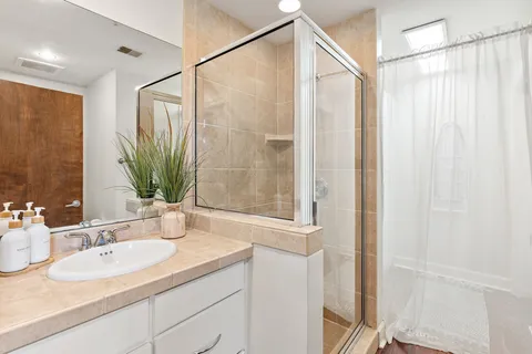 a bathroom with a granite countertop sink and a mirror