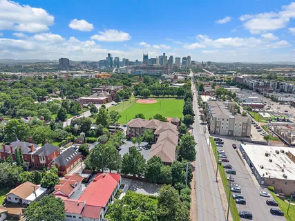 an aerial view of a city with lots of residential buildings ocean and mountain view in back