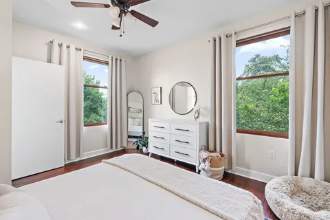 a bedroom with a bed a chandelier and a window