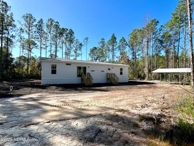 a view of a house with backyard and trees