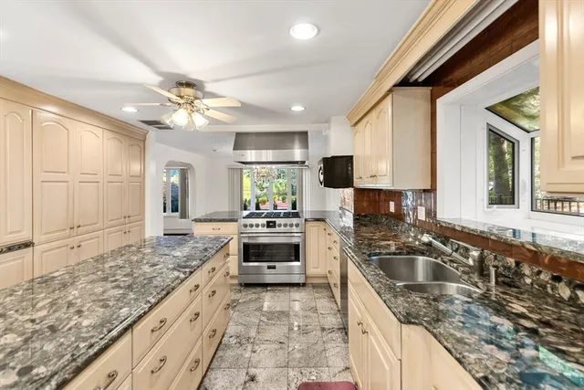 a kitchen with granite countertop a stove sink and cabinets