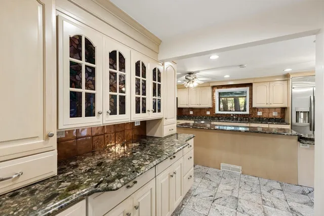 a large kitchen with kitchen island granite countertop a large window and a counter space