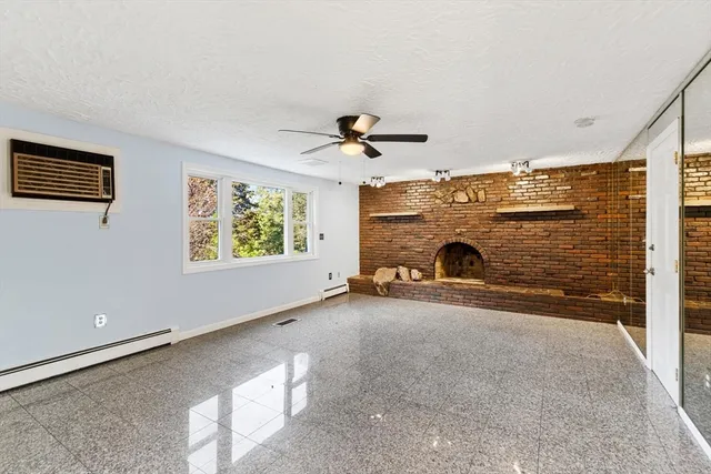 an empty room with fireplace and windows