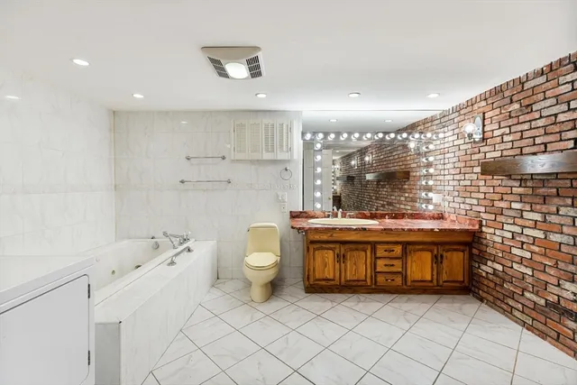 a bathroom with a granite countertop sink a toilet and bathtub