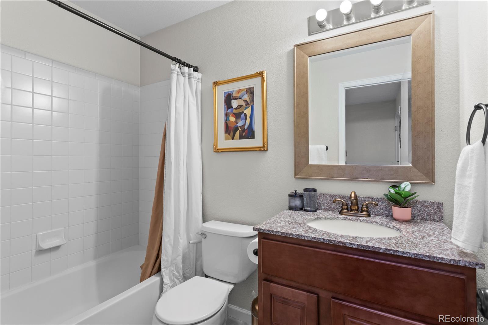 2212 Hyacinth Road Littleton, CO 80129 - Photo 18 of 44 a bathroom with a granite countertop sink toilet and shower