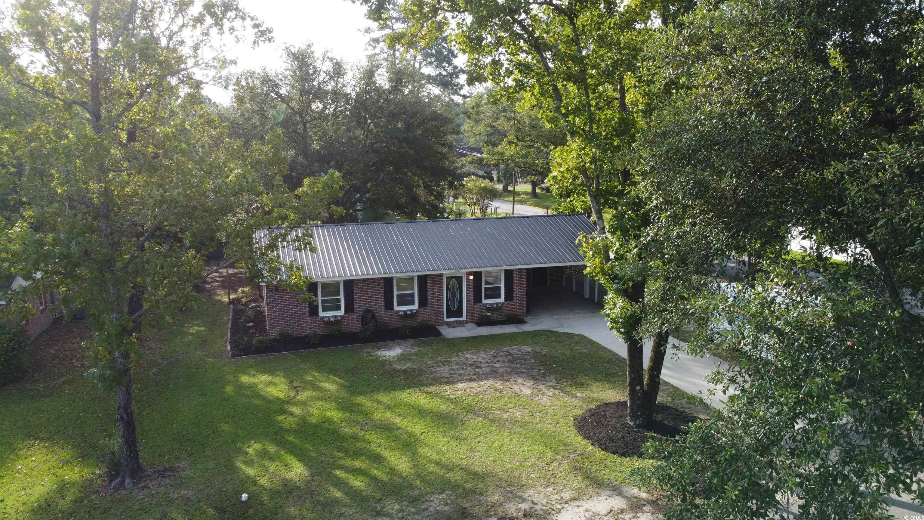 1607 Oak Street Georgetown, SC 29440 - Photo 30 of 31 Single story home featuring a carport, a metal roof, concrete driveway, brick siding, and a front yard