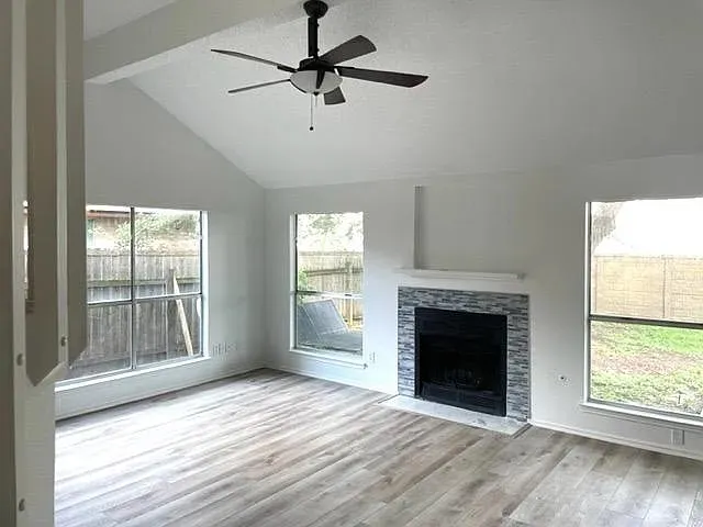 wooden floor fireplace and windows in an empty room
