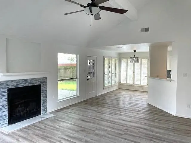a view of an empty room with a fireplace and a window