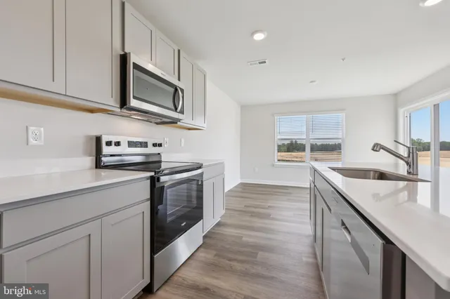 a kitchen with stainless steel appliances granite countertop a sink and a stove top oven
