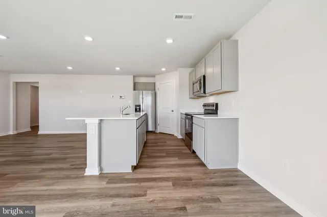 a view of kitchen with wooden floor and electronic appliances
