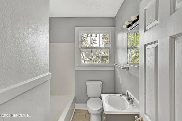 a bathroom with a toilet a sink and a window