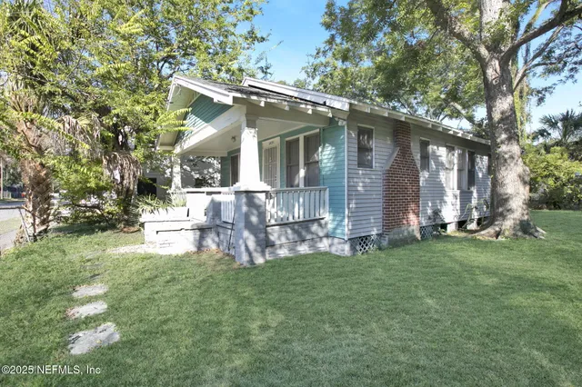 a view of a house with a yard and sitting area