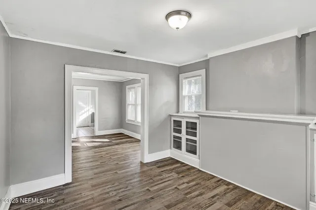 wooden floor in an empty room with a window