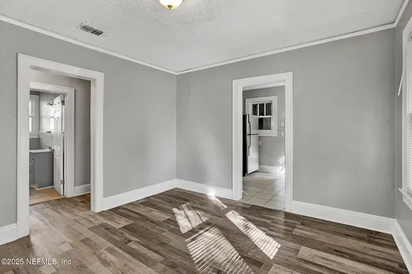 a view of a bedroom with wooden floor