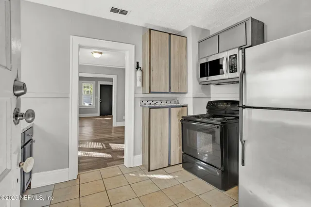 a kitchen with stainless steel appliances granite countertop a refrigerator and a stove