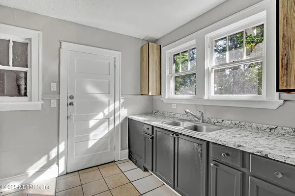 a bathroom with a granite countertop sink and a window