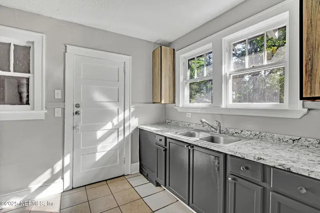 a bathroom with a granite countertop sink and a window