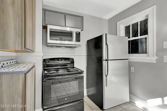 a kitchen with stainless steel appliances a refrigerator stove and microwave