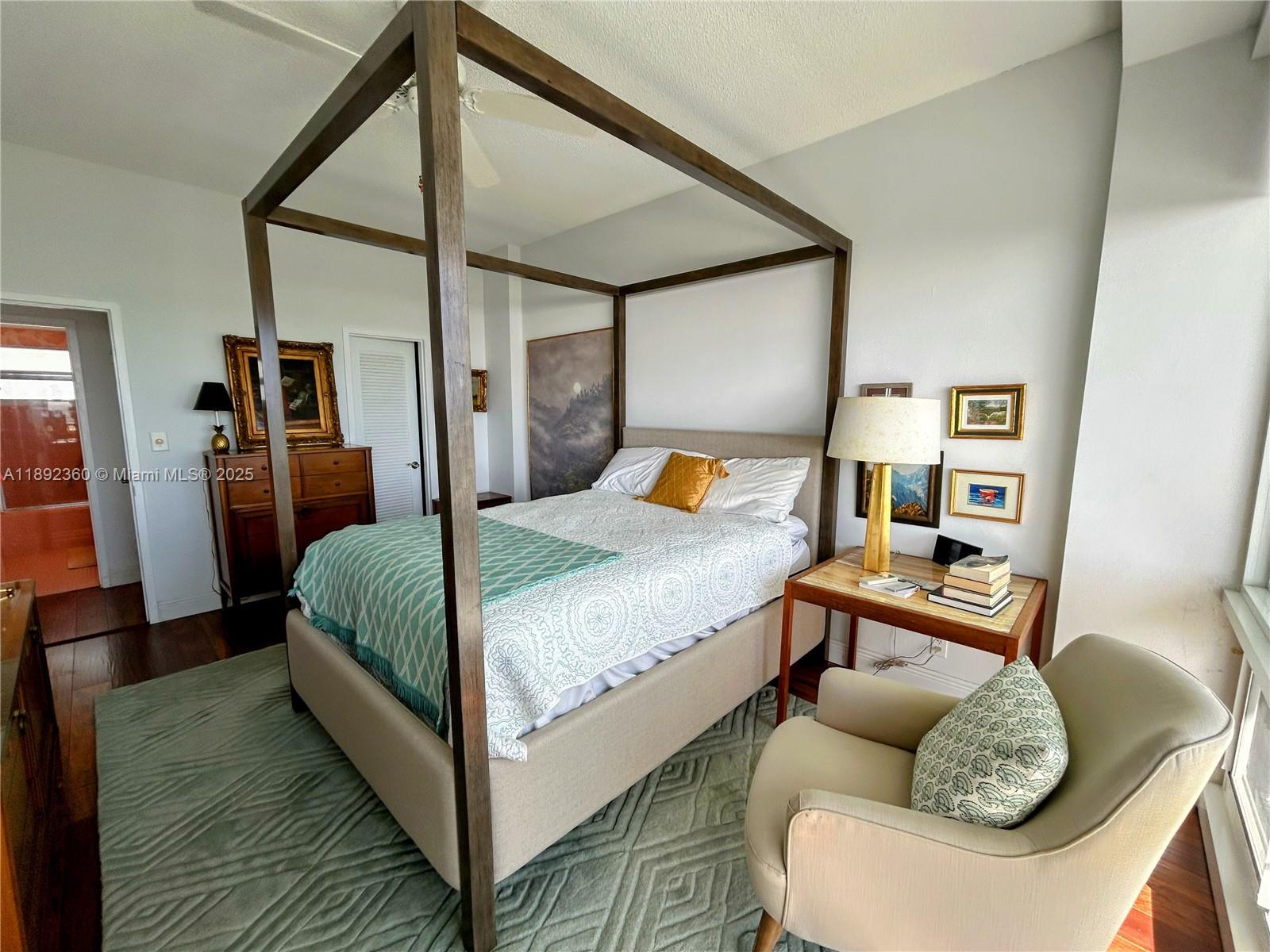 2840 North Ocean Boulevard, Unit 1008 Fort Lauderdale, FL 33308 - Photo 11 of 25 a bedroom with a bed and wooden floor