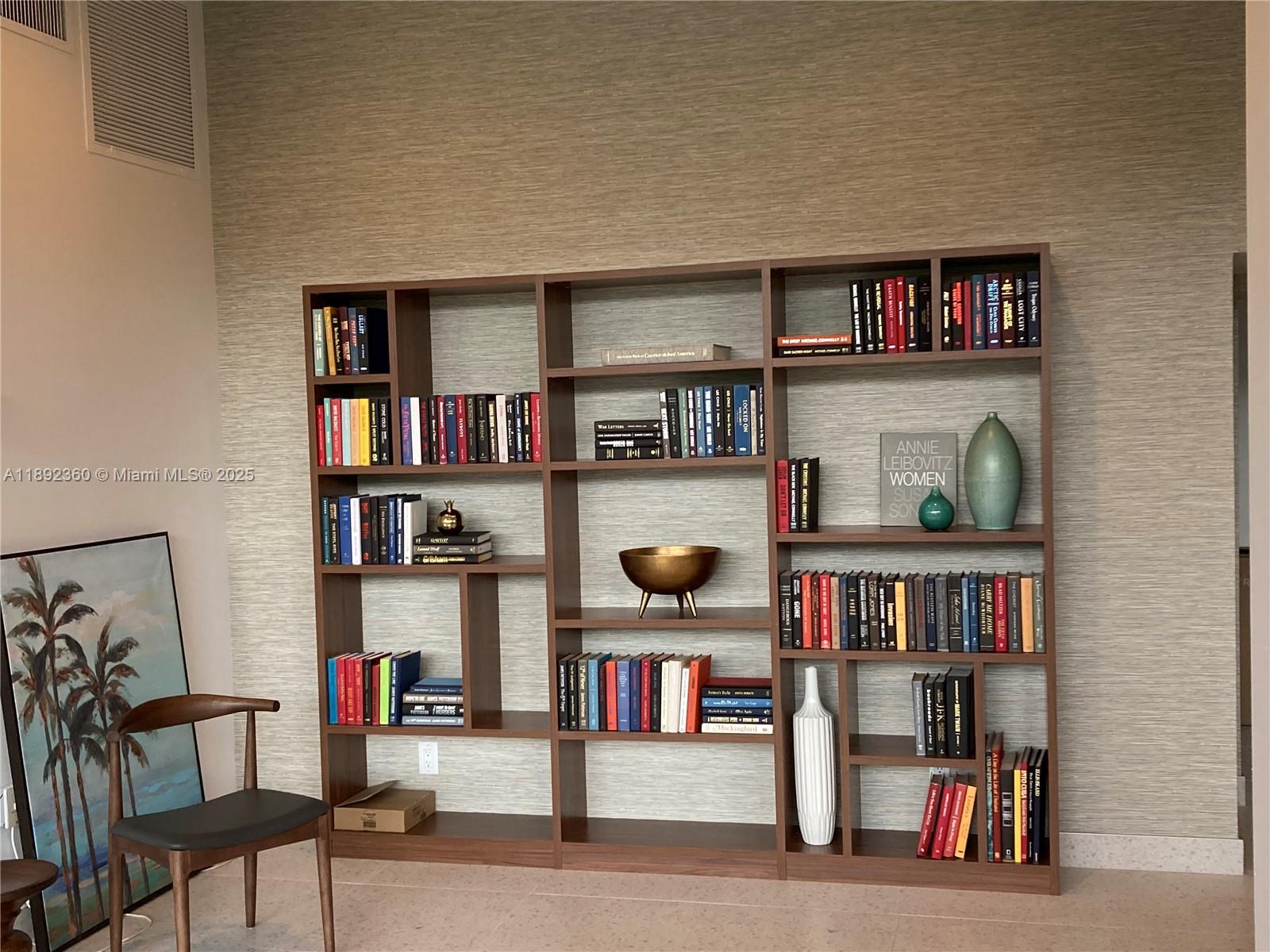 2840 North Ocean Boulevard, Unit 1008 Fort Lauderdale, FL 33308 - Photo 21 of 25 a living room with lots of books and a book shelf