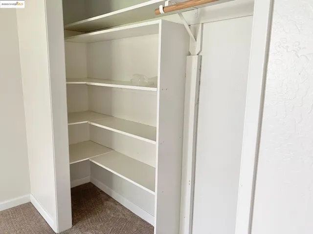 a view of walk in closet with empty racks