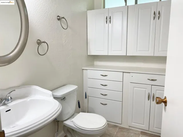 a bathroom with a toilet sink vanity and mirror