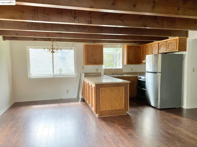 a kitchen with stainless steel appliances granite countertop a refrigerator a sink and a stove