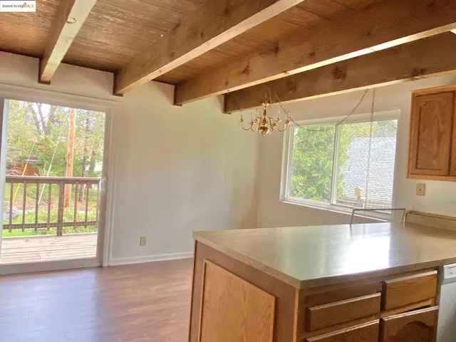 a view of a kitchen with wooden floor and a window