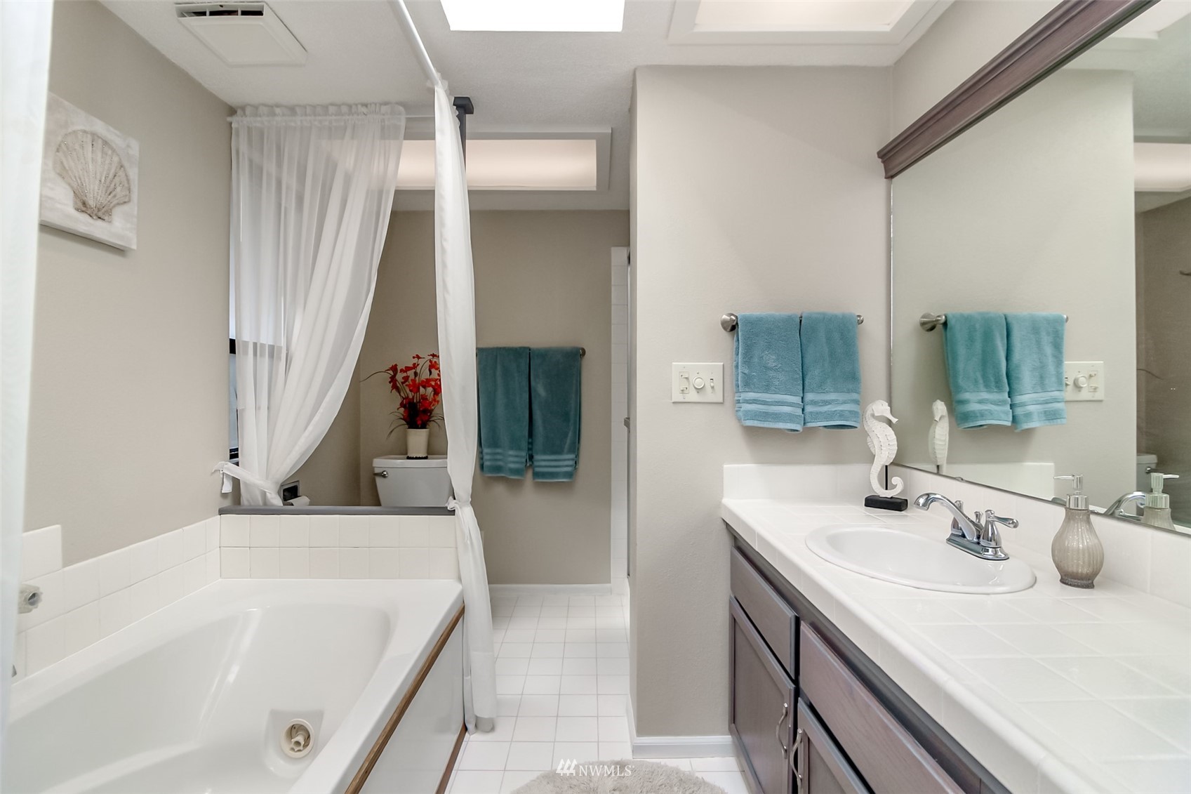 15007 Southeast 145th Place Renton, WA 98059 - Photo 14 of 34 a bathroom with a tub sink and mirror