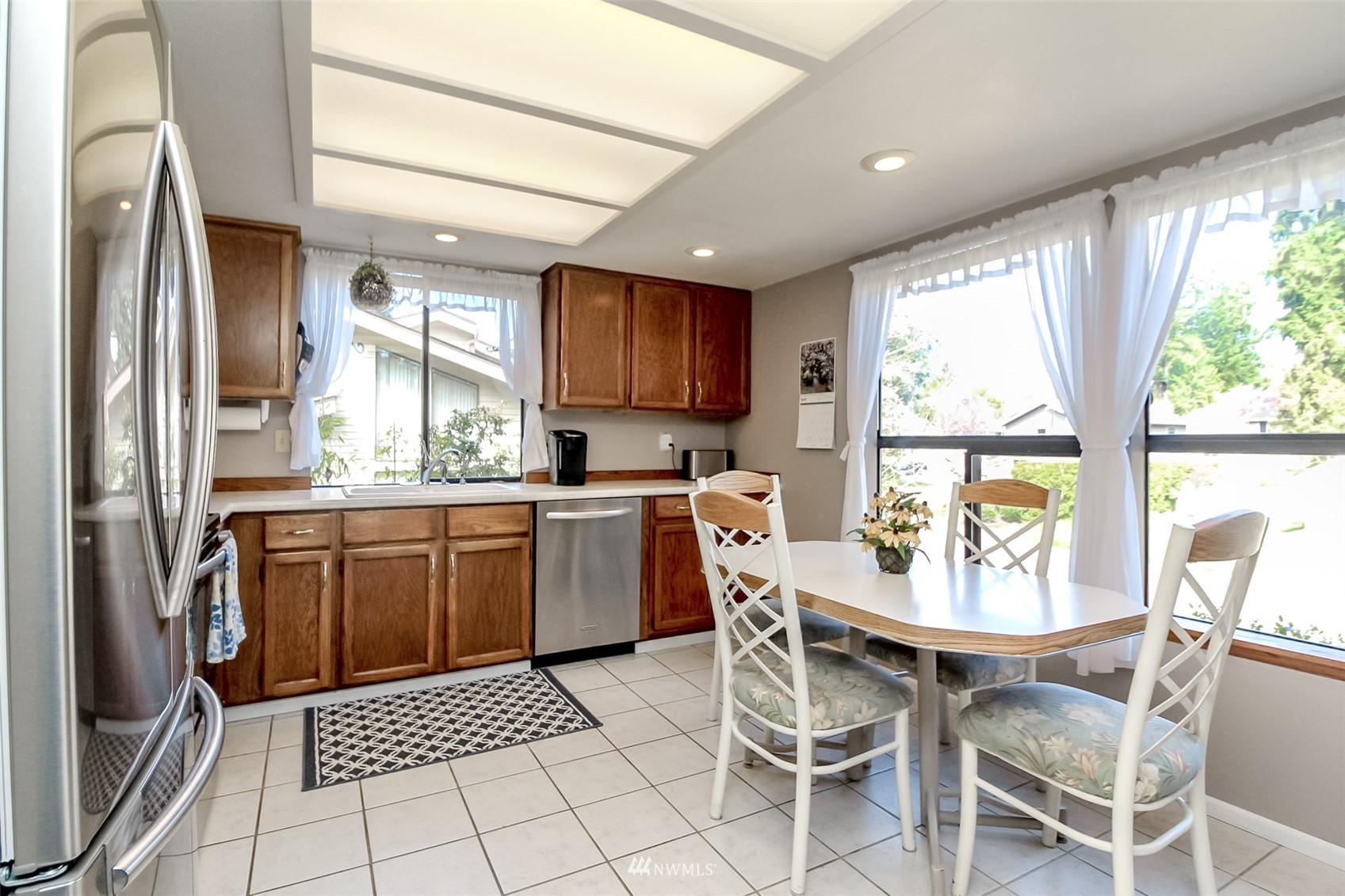 15007 Southeast 145th Place Renton, WA 98059 - Photo 7 of 34 a kitchen with a dining table chairs and refrigerator