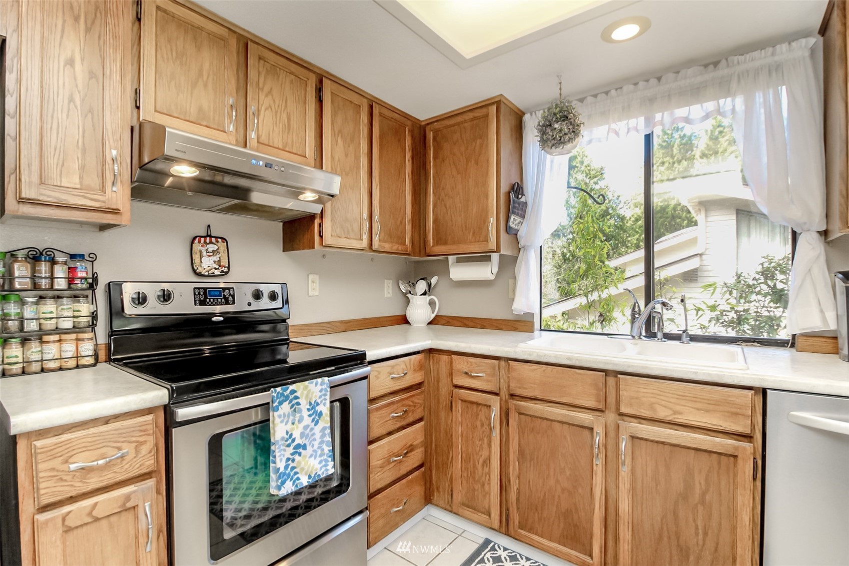 15007 Southeast 145th Place Renton, WA 98059 - Photo 8 of 34 a kitchen with stainless steel appliances granite countertop a stove a sink and a microwave
